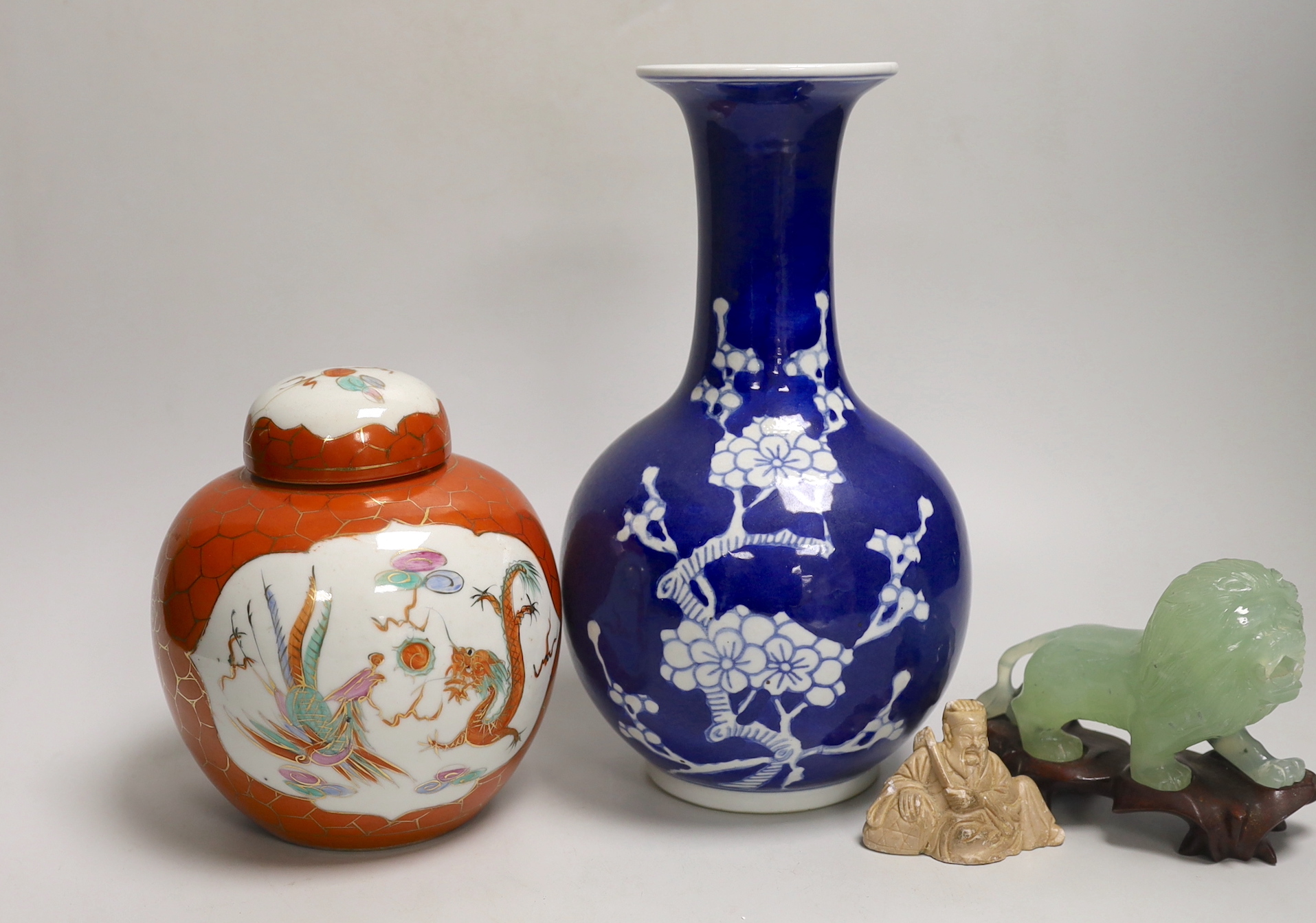 A Chinese blue and white vase, coral ground jar and cover, a bowenite carving of a lion and soapstone carving of a deity, tallest 24cm (4)